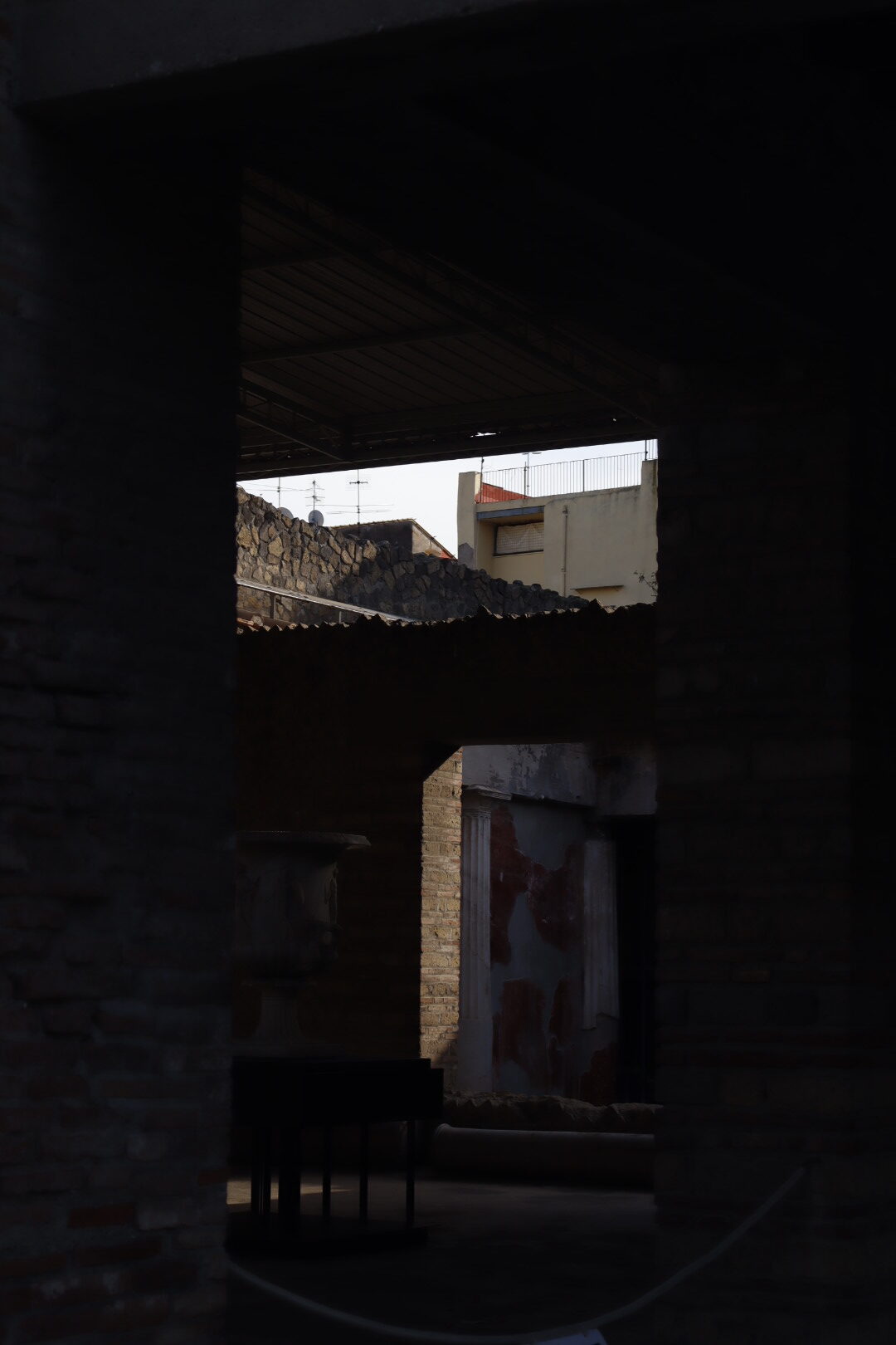 a shadowy underpass revealing buildings in the background