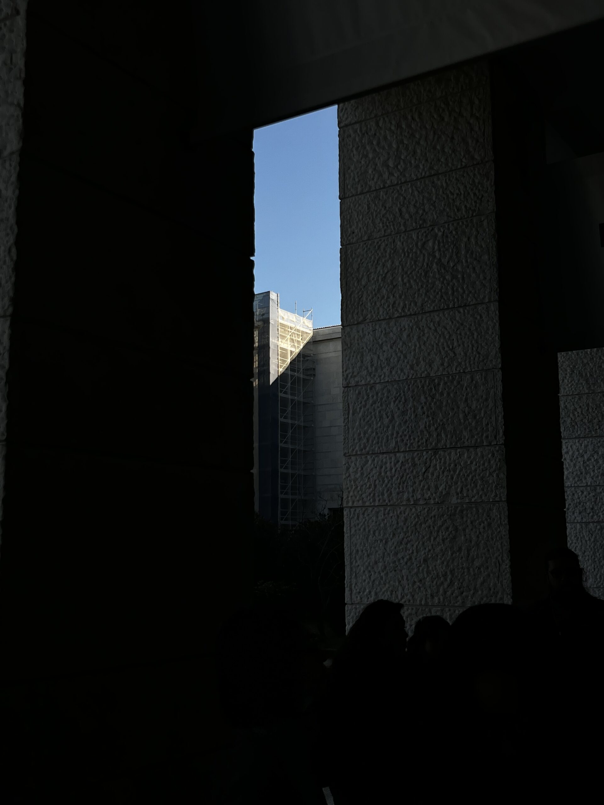 an opening of a building revealing a blue sky
