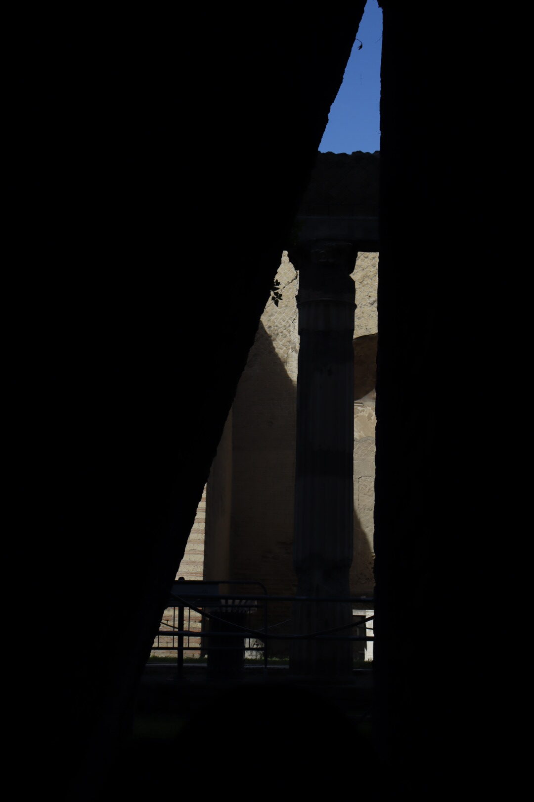 blue sky, and a building facade as seen from a dark room