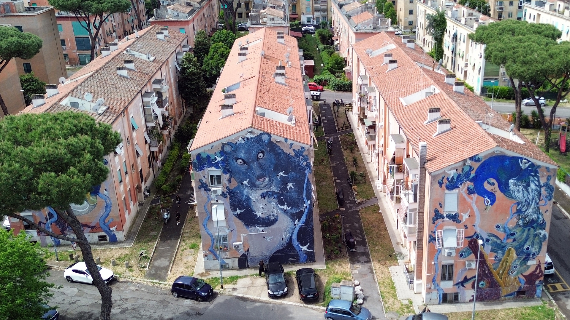 a view of residential buildings with painted murals on the side