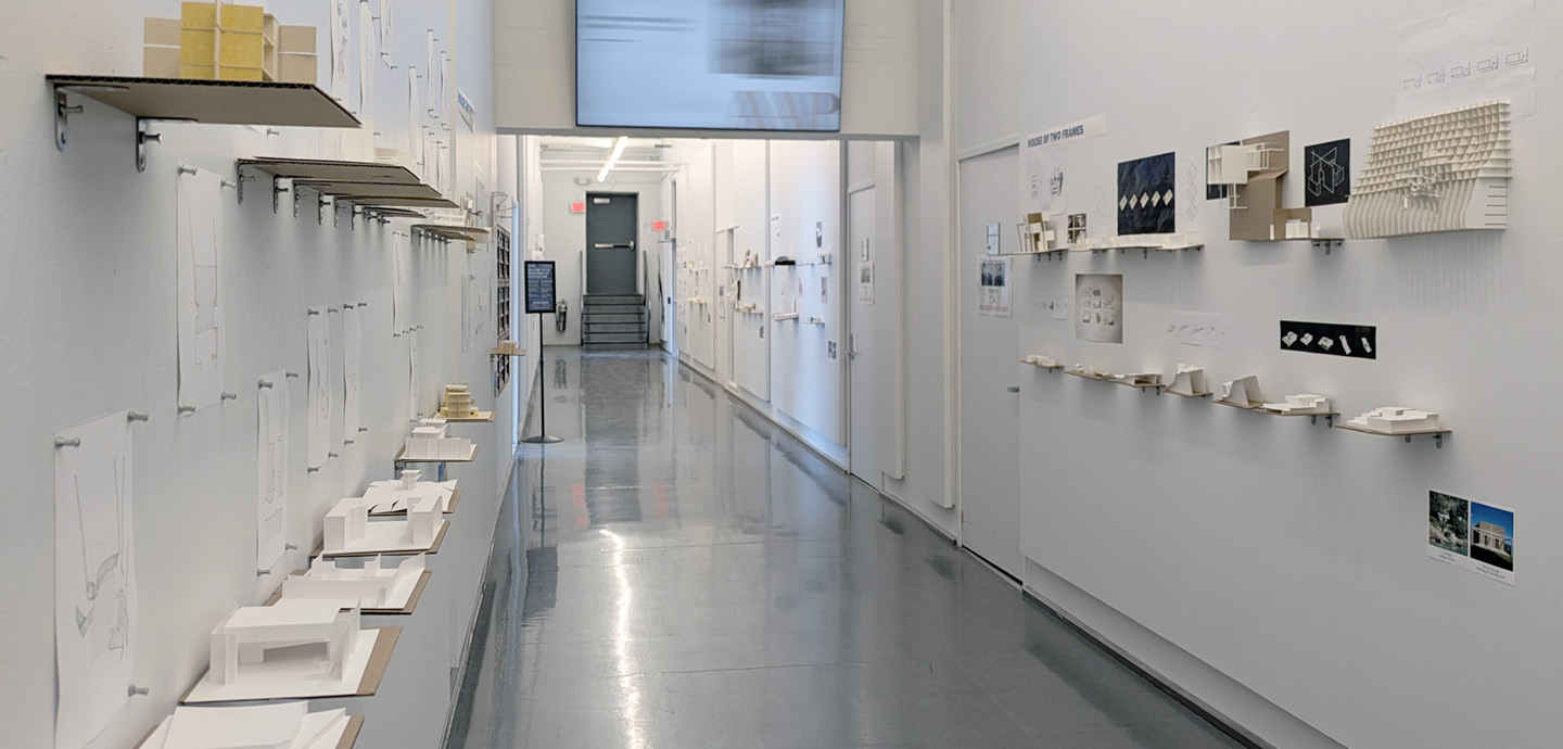 a hallway with 3D architectural models on the walls