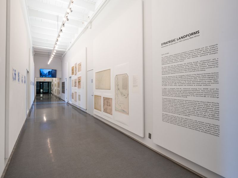 a hall way with white walls and gray floors