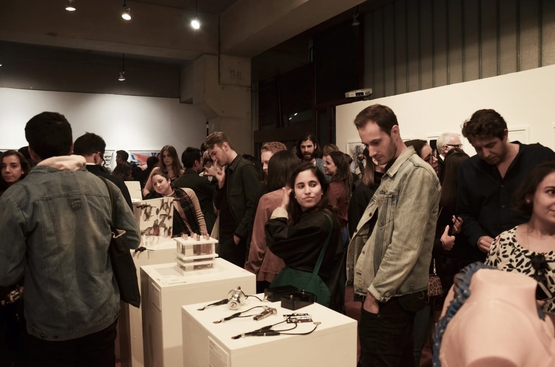 people browsing a selection of objects on pedestals in a gallery