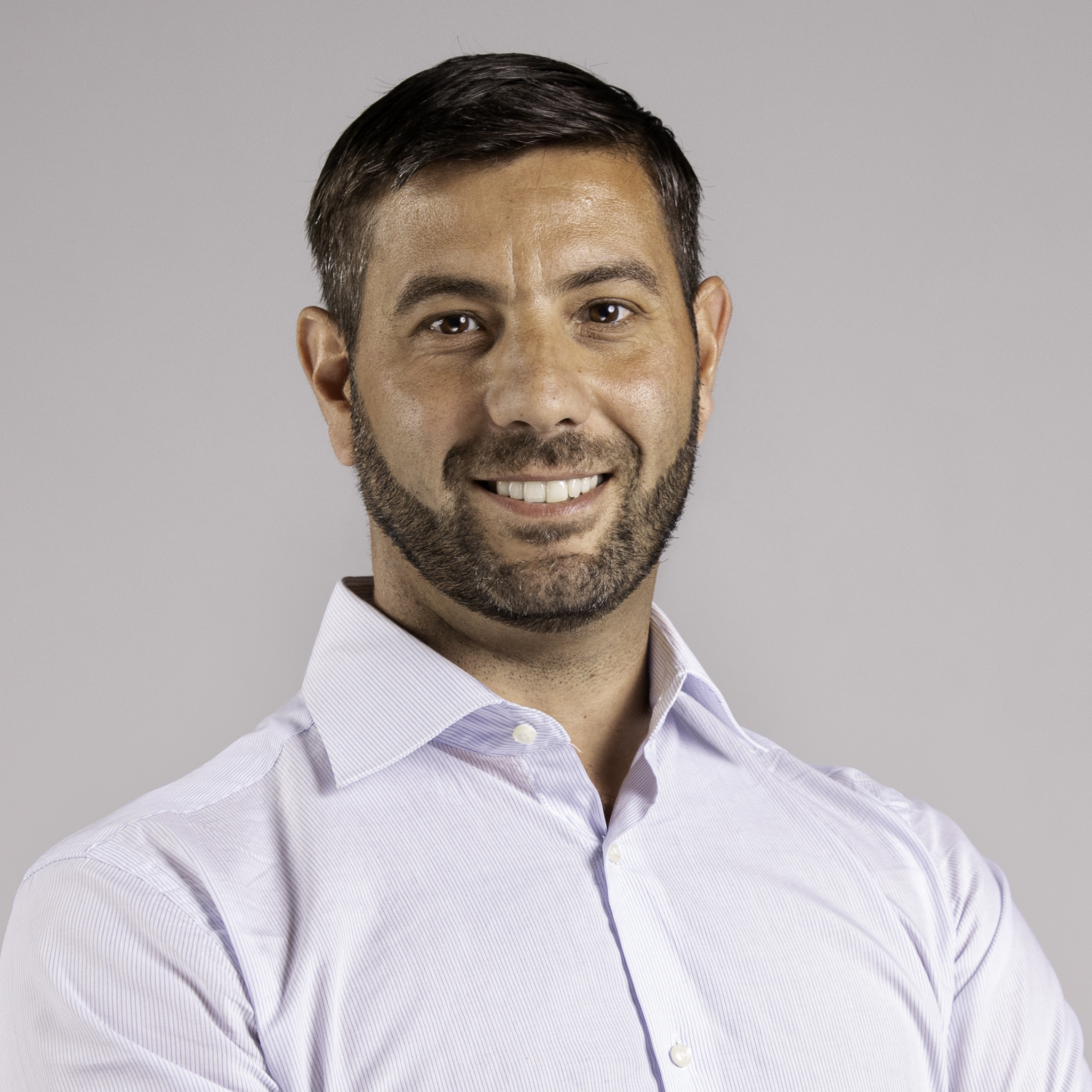 Portrait of a man in a light-colored shirt against a neutral background