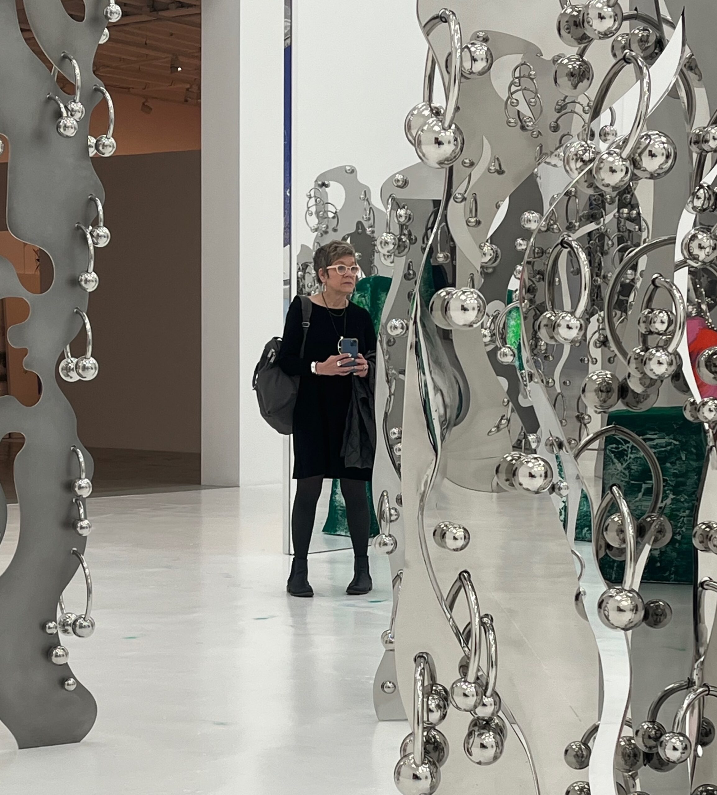 A woman standing in front of an elaborate metal sculpture.