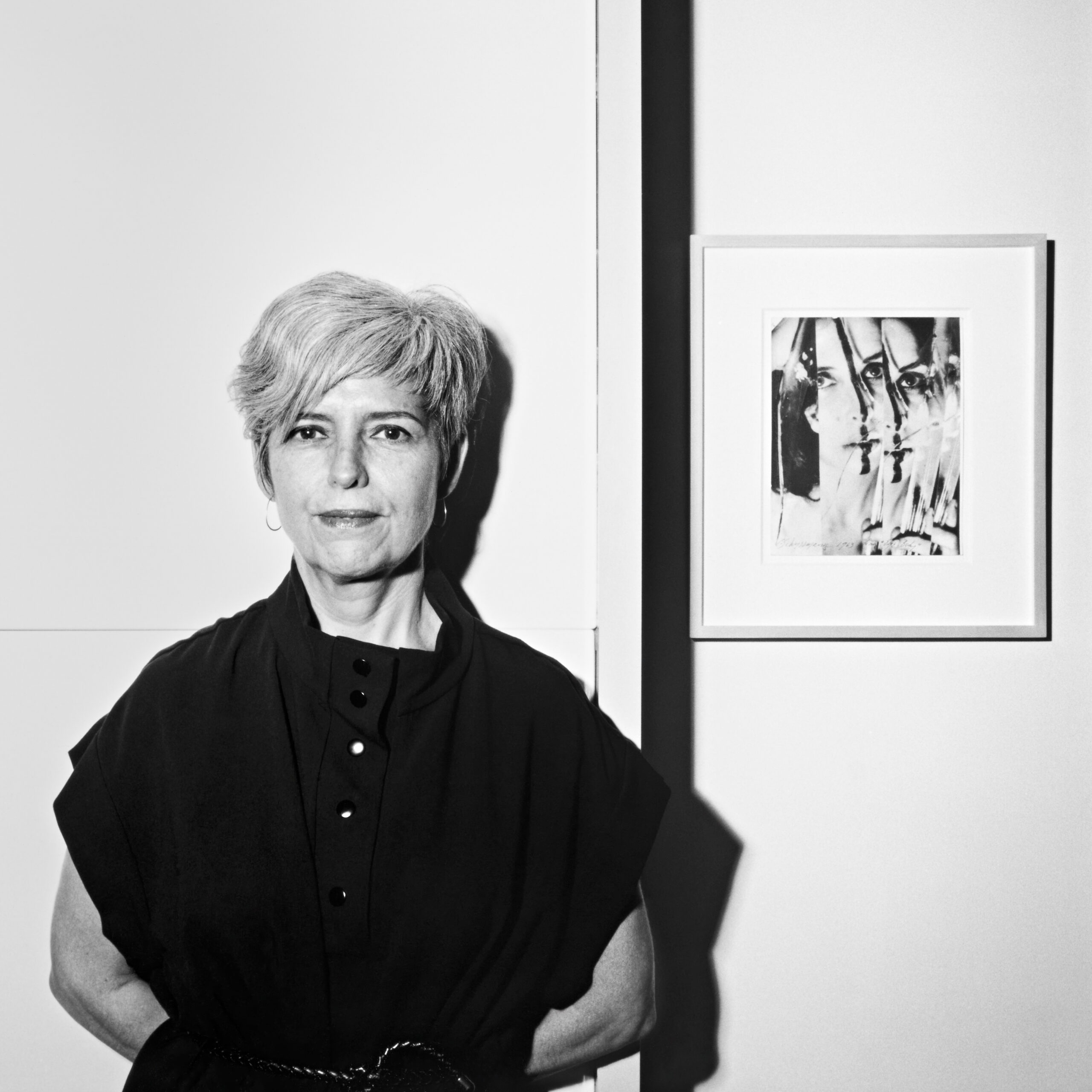 A woman with short gray hair, wearing a large black tunic.