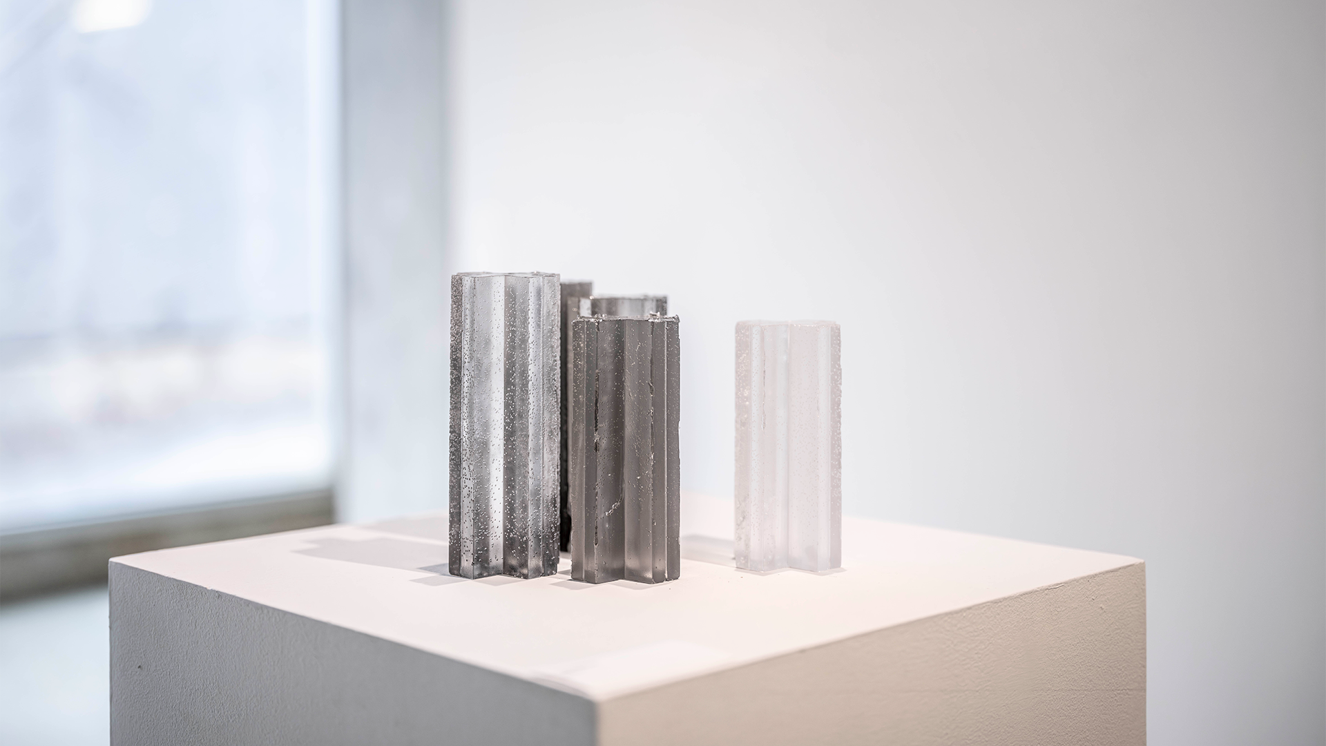 multiple glass pillar sculptures on pedestal