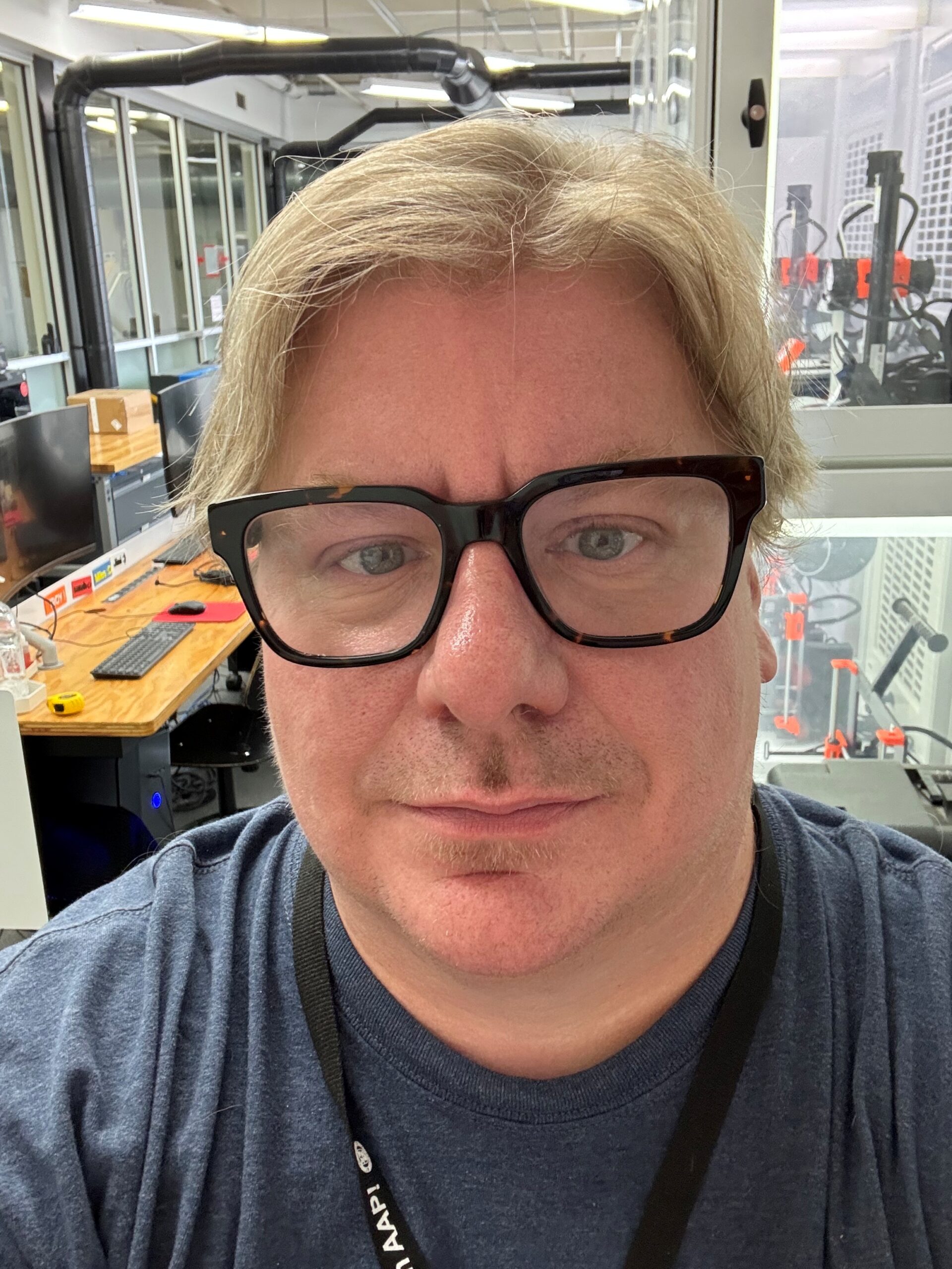 A man with blonde hair and black rectangular glasses.