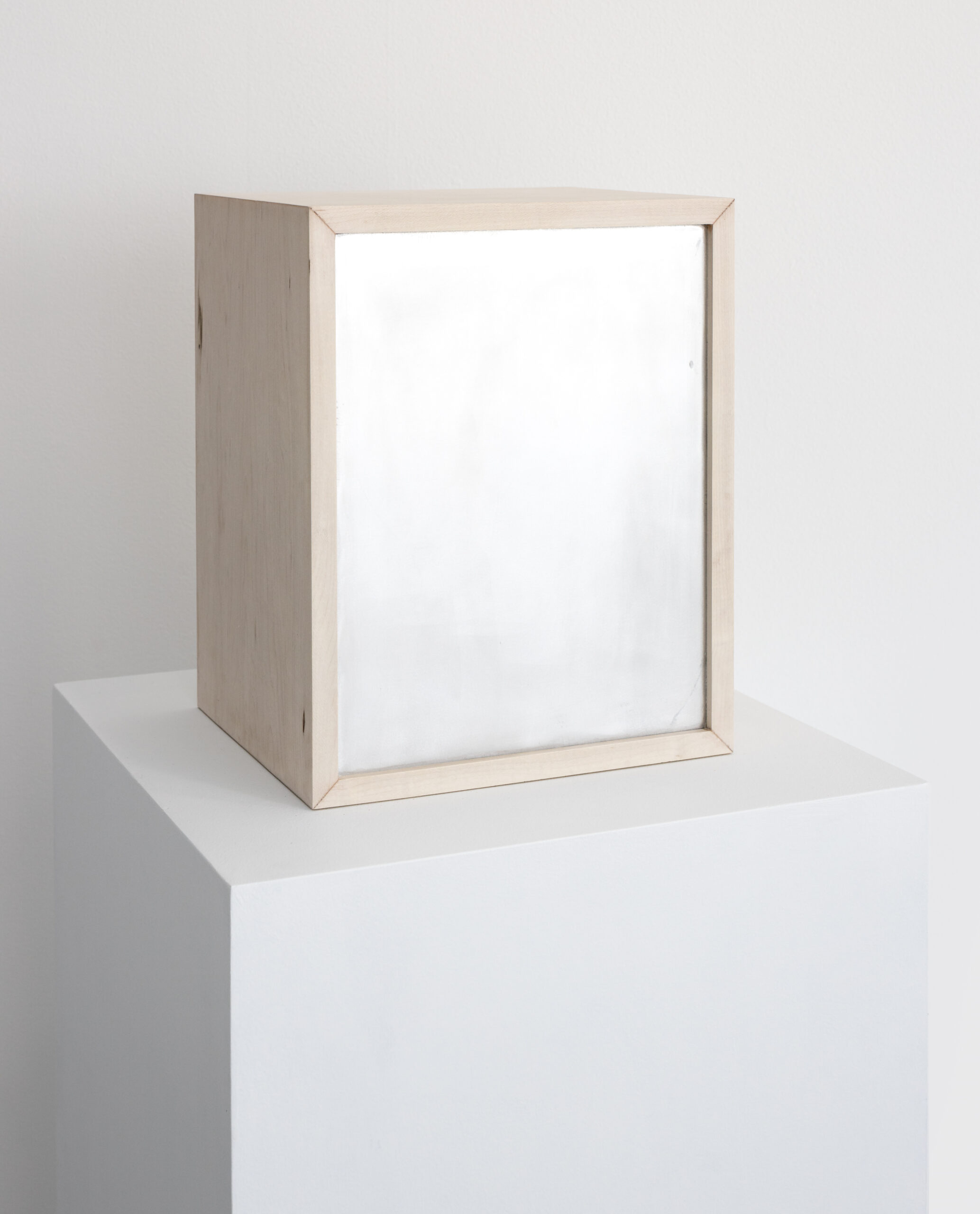 A wooden box on a white pedestal