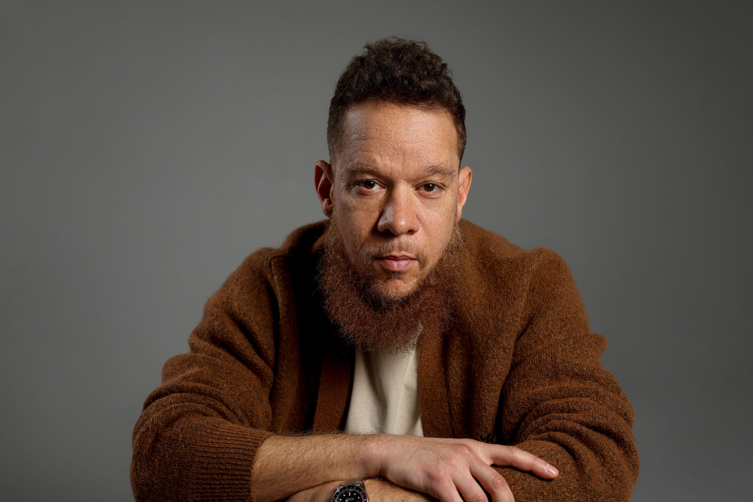 Headshot of a man with curly reddish-brown hair and a full beard
